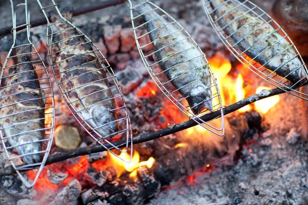 poissons entrain de cuire en grillade au-dessus d'un feu de bois