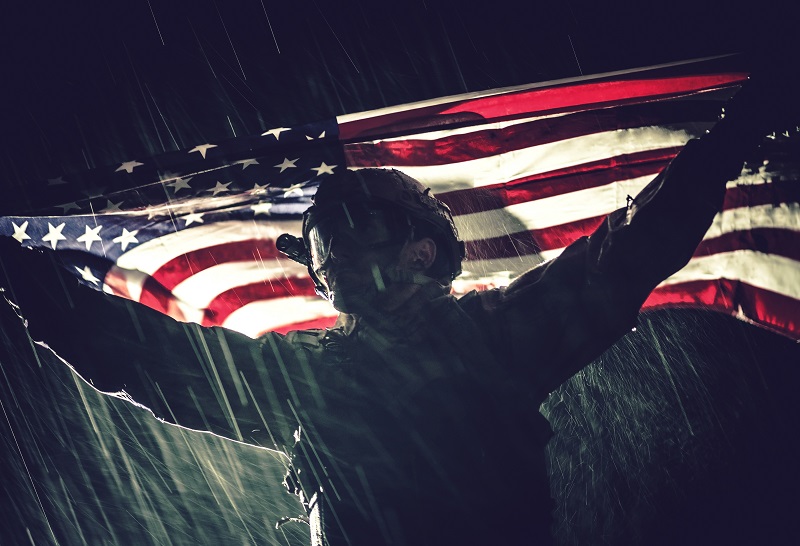 Fier soldat de l'armée américaine avec le drapeau national dans les mains lors d'orages violents et de pluies. Les états-unis d'Amérique. Notion de victoire. Thème militaire.